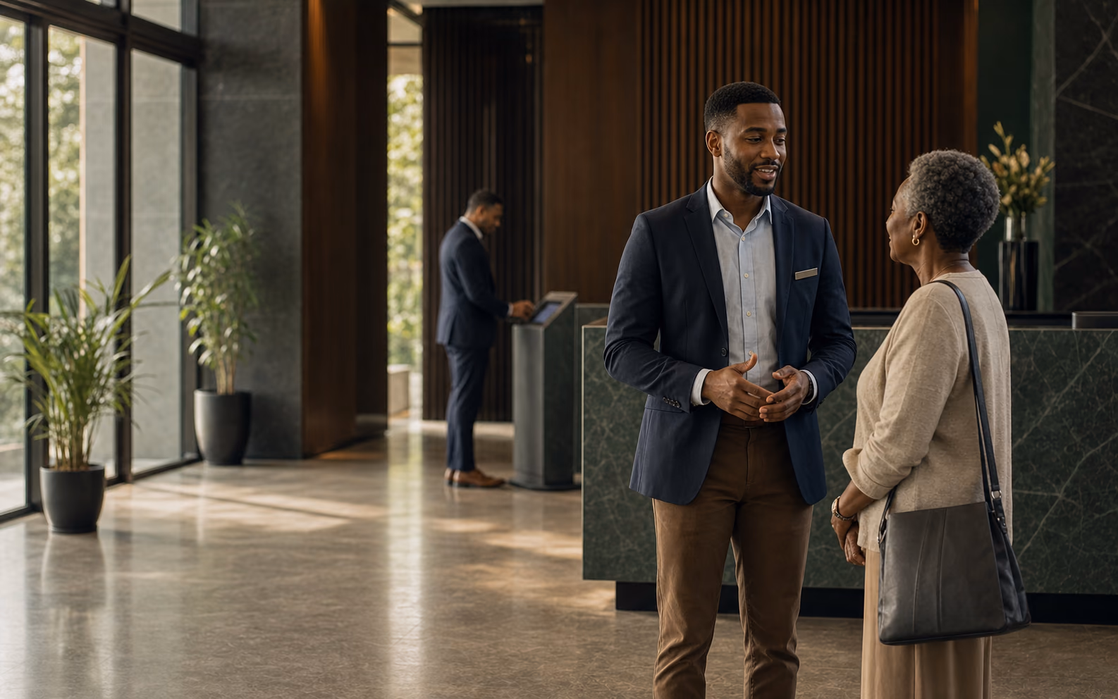 A front-of-house professional gives an older visitor his full attention.